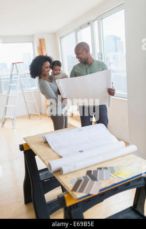 Family examining blueprints in new home Stock Photo