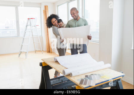 Family examining blueprints in new home Stock Photo