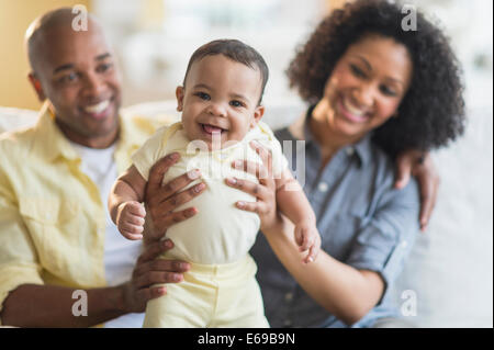 Parents playing with baby in living room Stock Photo