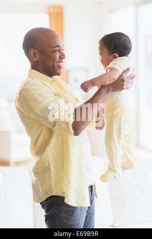 Smiling father holding baby Stock Photo