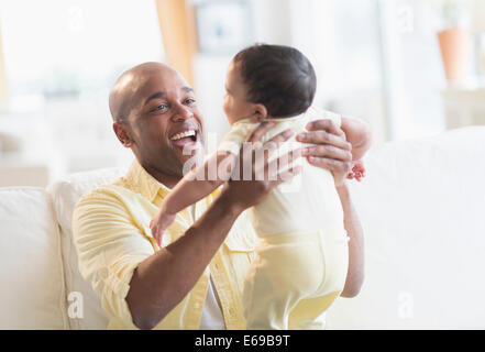 Smiling father playing with baby Stock Photo