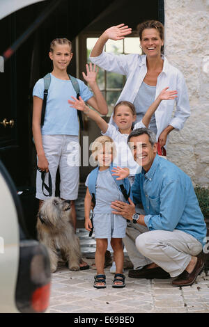 Caucasian family waving from doorway Stock Photo