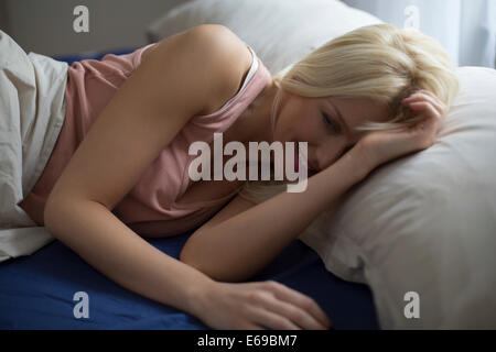 Caucasian woman laying in bed Stock Photo
