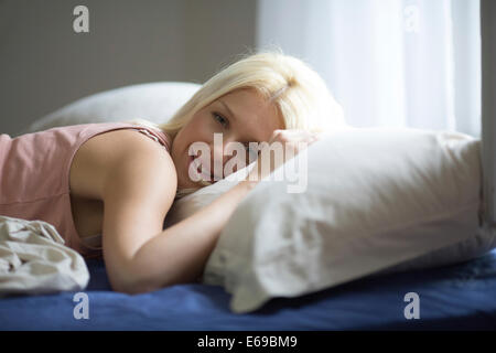 Caucasian woman laying in bed Stock Photo