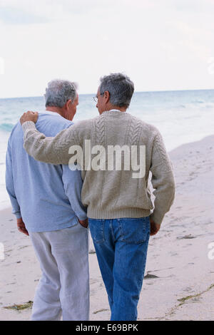 Caucasian father and son walking on beach Stock Photo