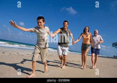 Caucasian family holding hands on beach Stock Photo
