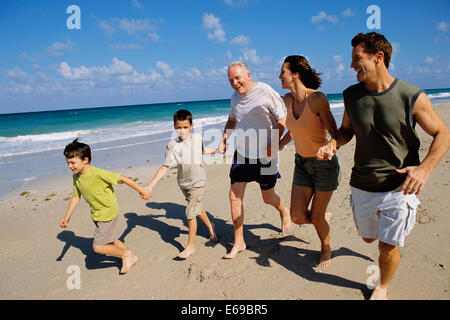 Caucasian family holding hands on beach Stock Photo