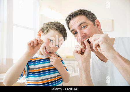 Caucasian father and son flossing their teeth Stock Photo