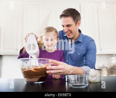 Caucasian father and daughter baking together Stock Photo