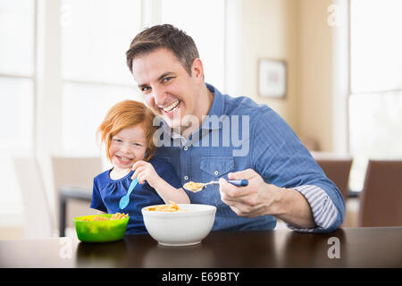 Caucasian father and daughter eating breakfast together Stock Photo