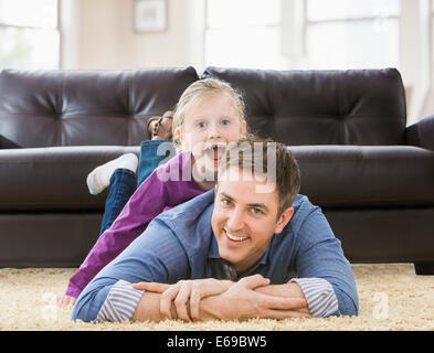 Caucasian father and daughter playing in living room