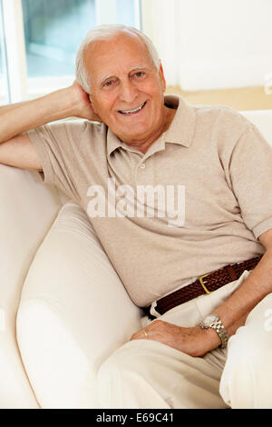 Senior man sitting on sofa Stock Photo