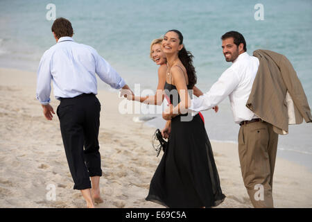 Couples walking together on beach Stock Photo