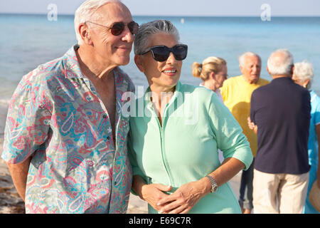 Senior couples walking on beach Stock Photo