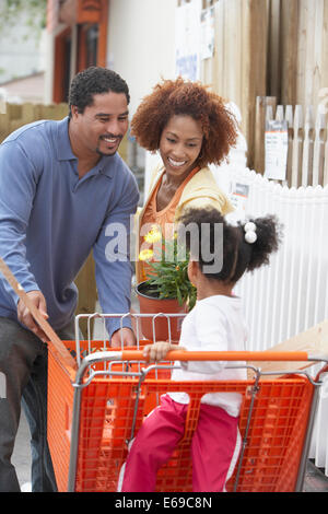 Couple pushing daughter in shopping cart Stock Photo