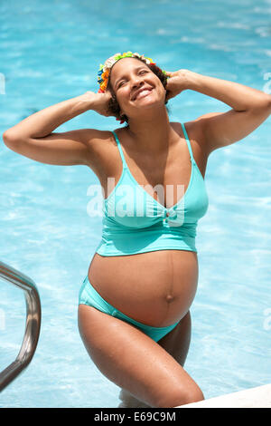 Pregnant woman smiling in swimming pool Stock Photo