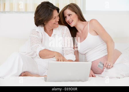 Mother and pregnant daughter using laptop Stock Photo