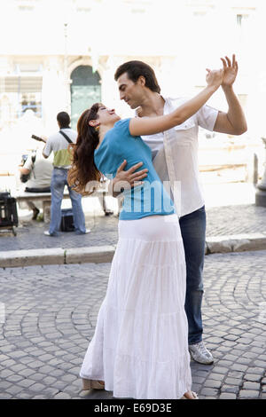 Caucasian couple dancing on city street Stock Photo