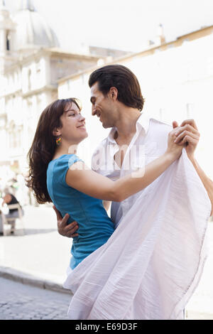 Caucasian couple dancing on city street Stock Photo