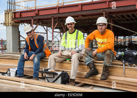 Caucasian workers smiling at construction site Stock Photo