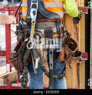 Hispanic worker wearing tool belt at construction site Stock Photo