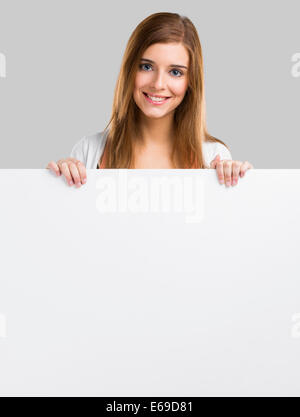 Young and beautiful woman holding a big blank board, isolated over white background Stock Photo