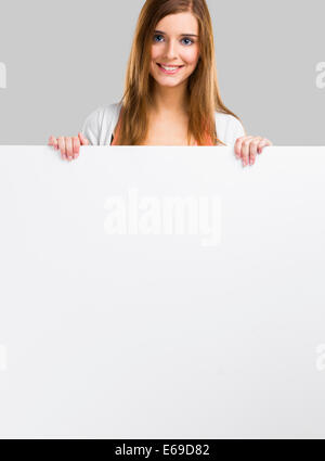 Young and beautiful woman holding a big blank board, isolated over white background Stock Photo