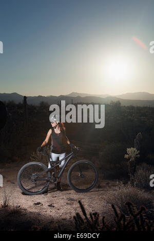 Mountain biker standing in desert Stock Photo