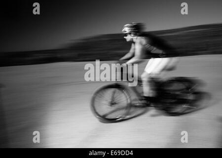 Woman riding mountain bike in desert Stock Photo