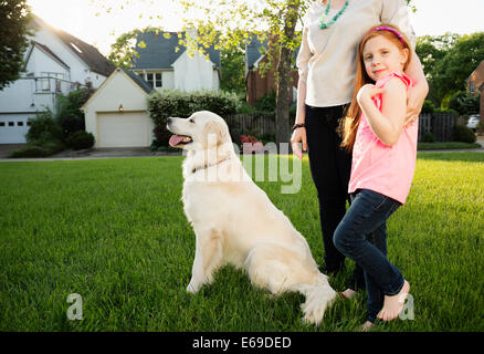 Caucasian mother and daughter with dog in park Stock Photo
