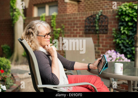 Caucasian woman using tablet computer outdoors Stock Photo