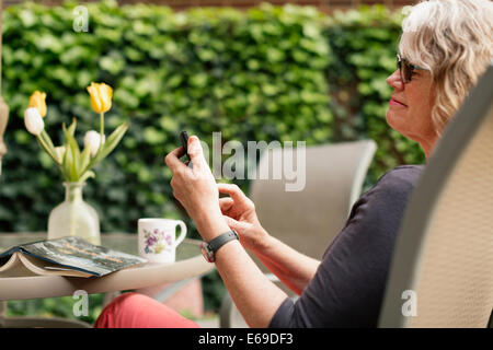 Caucasian woman using cell phone outdoors Stock Photo