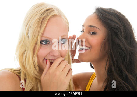 Two girls are talking secrets to each other isolated over white background Stock Photo