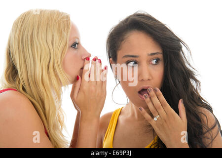 Two girls are talking secrets to each other isolated over white background Stock Photo