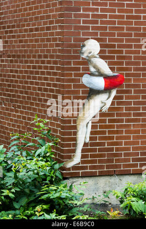 Graffiti art of a man trapped inside a life buoy ring painted on a red brick wall Stock Photo