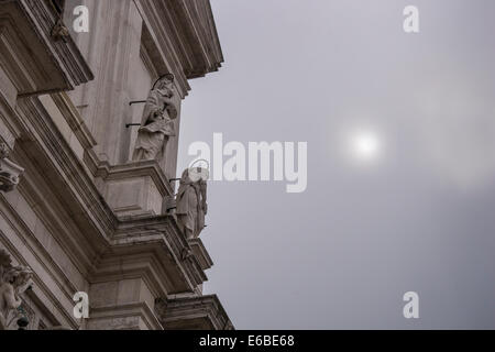 The sun trying to break though the early morning haze next to the facade of the Church of Santa Maria Assunta in Venice. Stock Photo