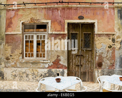 Antique wooden door in a house with worn stone wall texture. Stock Photo