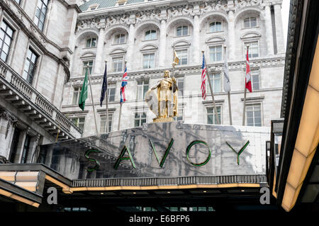 Sculpture, flags and sign at the main entrance to the Savoy Hotel, Knightsbridge, London Stock Photo