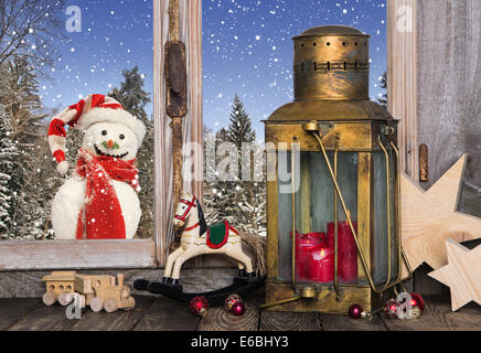 Christmas window decoration with old toys and an old lantern with a red candle. Stock Photo