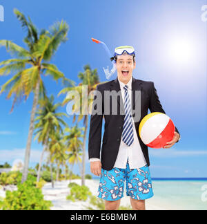 Man standing on beach with snorkel and beach ball shot with a tilt and shift lens Stock Photo