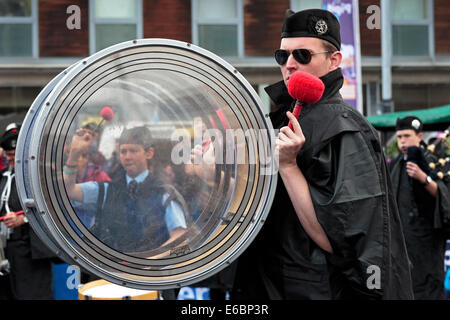 Drum major playing his transparent bass drum with the image of a young girl playing the side drum in the distance,Glasgow Stock Photo