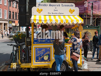 People buying freshly squeezed lemonade cold drink drinks from street vendor stall kiosk stand in summer York North Yorkshire England UK GB Britain Stock Photo