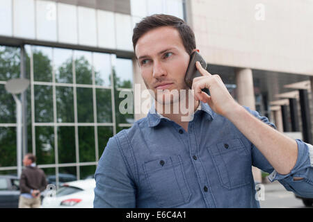 Businessman talking on the phone in the street Stock Photo