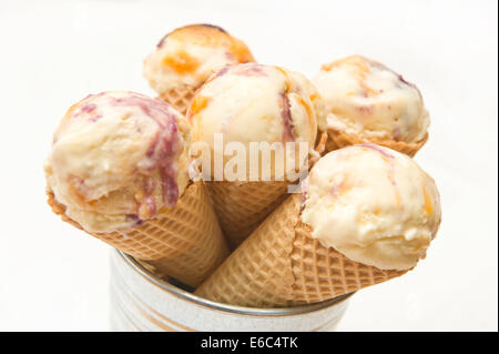 Five home made vanilla ripple ice cream in a waffle cone in vintage retro tin can on a white background. Stock Photo