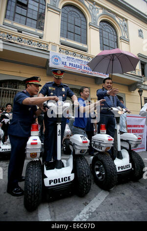 Manila, Philippines. 20th Aug, 2014. Former President and current Mayor of Manila Joseph Estrada (1st R) rides an electric personal transporter at Manila City Hall in Manila, the Philippines, Aug. 20, 2014. The electric motorized vehicles will be used by policemen for increased visibility and quick response in tourist spots in Manila. © Rouelle Umali/Xinhua/Alamy Live News Stock Photo