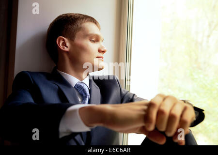 Young man sitting on windowsill - waiting bride Stock Photo