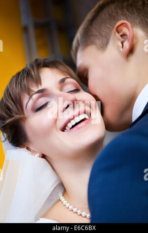 Beautiful bride smiling while groom telling her something Stock Photo