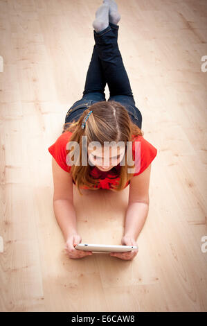 girl 10 or 11 years old, reading on a tablet Stock Photo