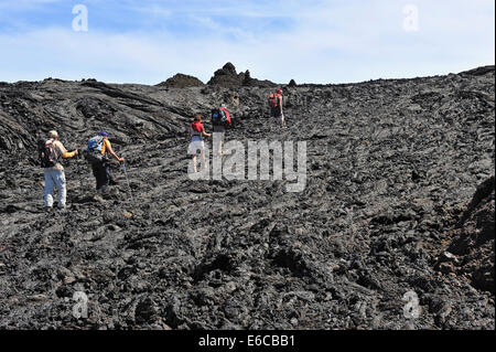 Group of hikers walking on cooled lava, Mauna Loa Volcano, Big Island, Hawaii Volcanoes National Park, USA Stock Photo