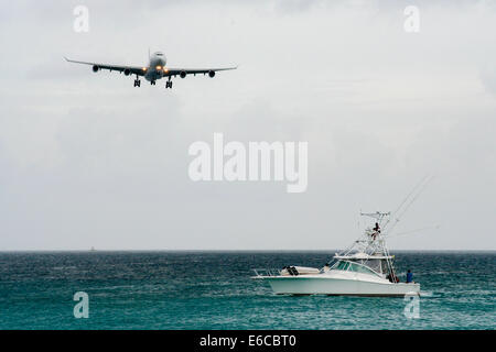 Air France Airbus A340-300 approaches St. Maarten airport, as a boat with spectators watches on. Stock Photo